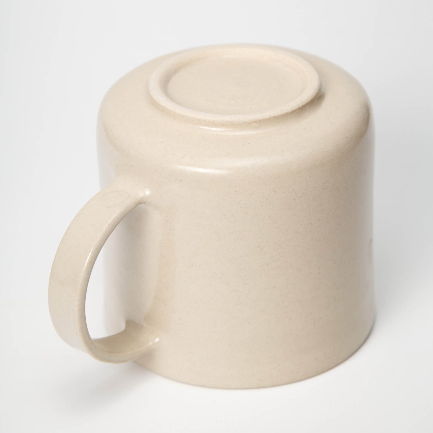 Beige ceramic mug with a lid on a white background