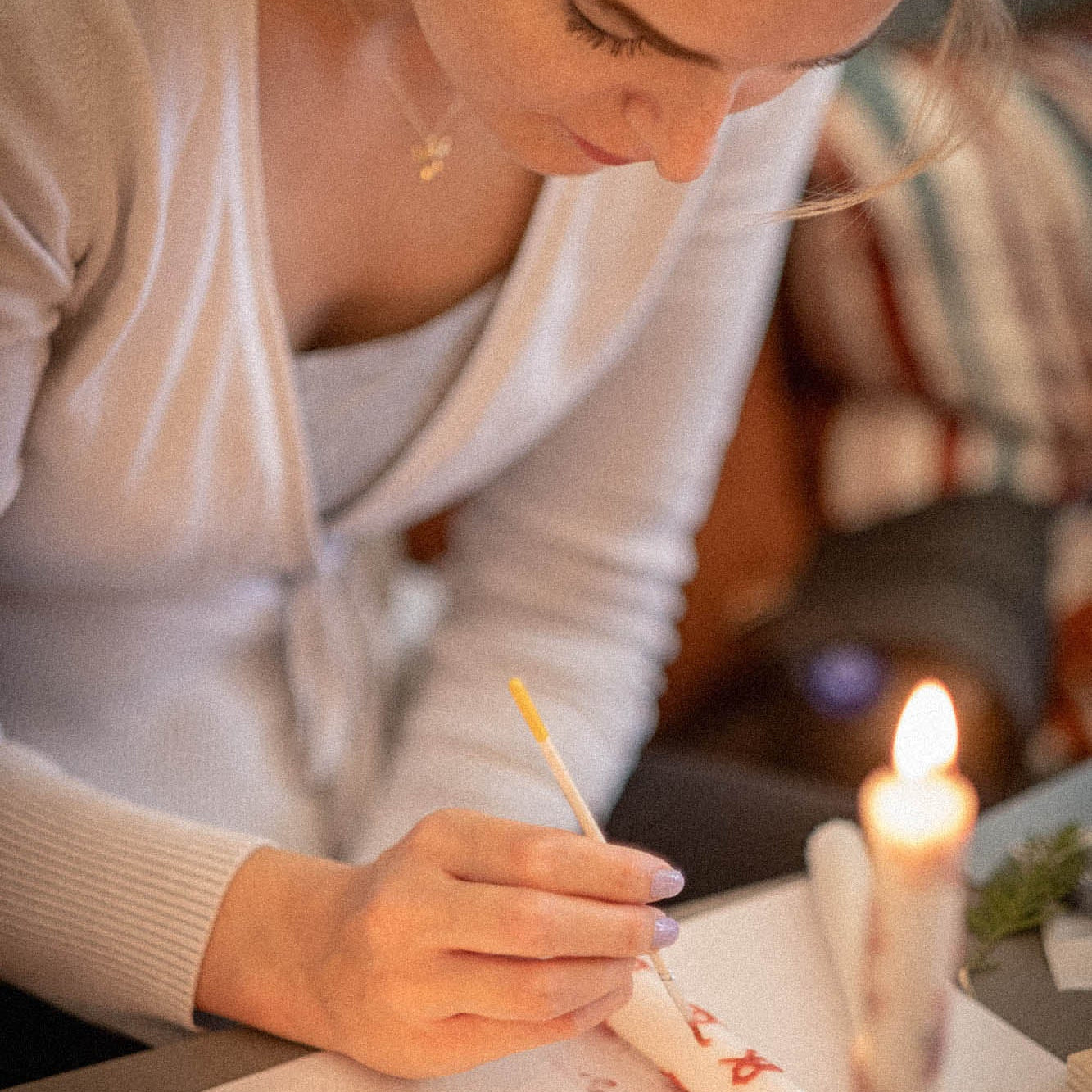 A woman in a candle painting workshop