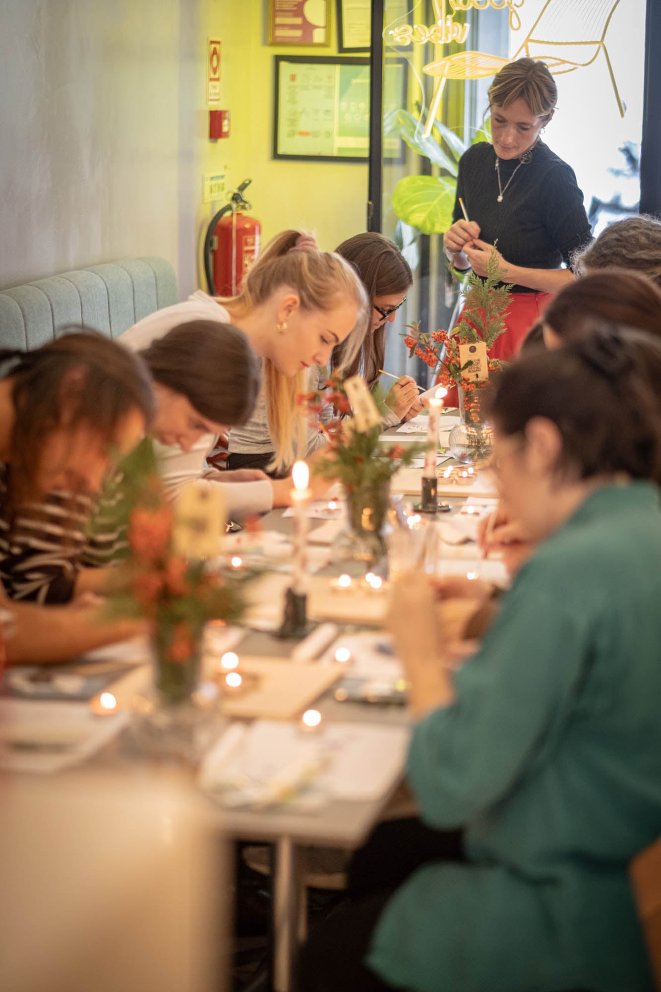 People dining at a restaurant with floral centerpieces on the table.