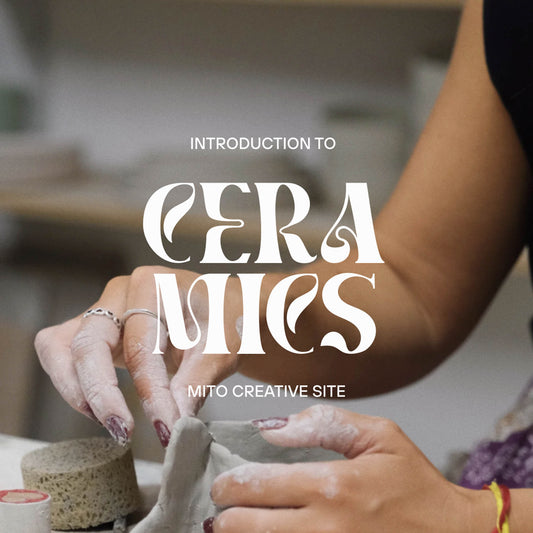 Ceramic Workshop in Lisbon, Portugal. A close-up of hands shaping clay pottery, with large overlaid text reading 'INTRODUCTION TO CERAMICS.