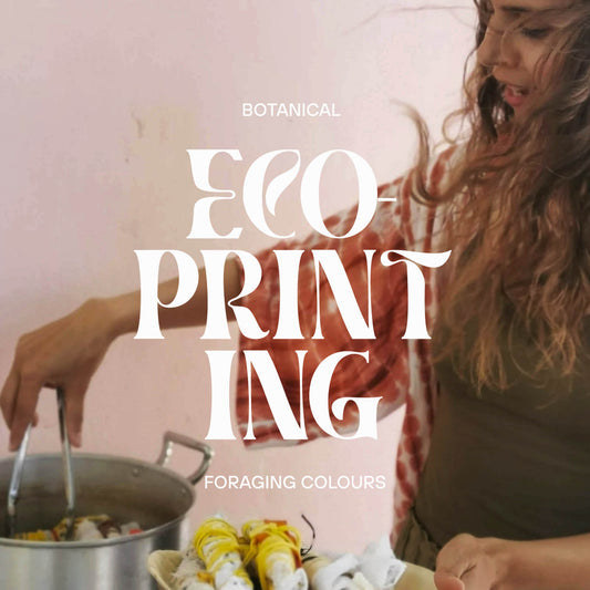 A woman in a rustic kitchen scene with large white text reading 'BOTANICAL ECO-PRINTING FORAGING COLOURS' overlaid across the center. She is standing beside a pot and holding foraged items, with a soft pink background.