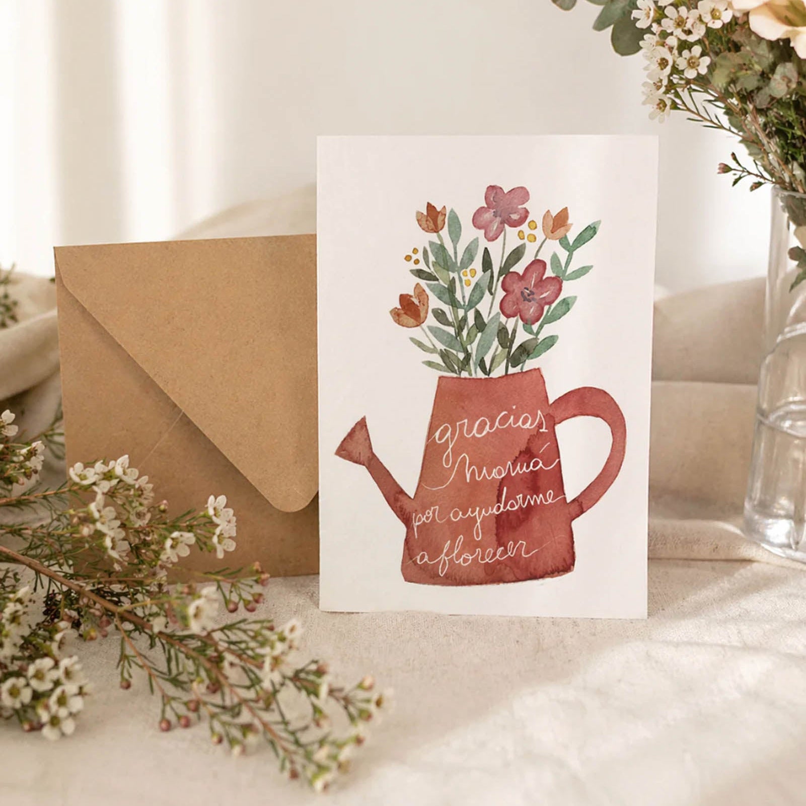 Card with floral design and envelope on a table with flowers