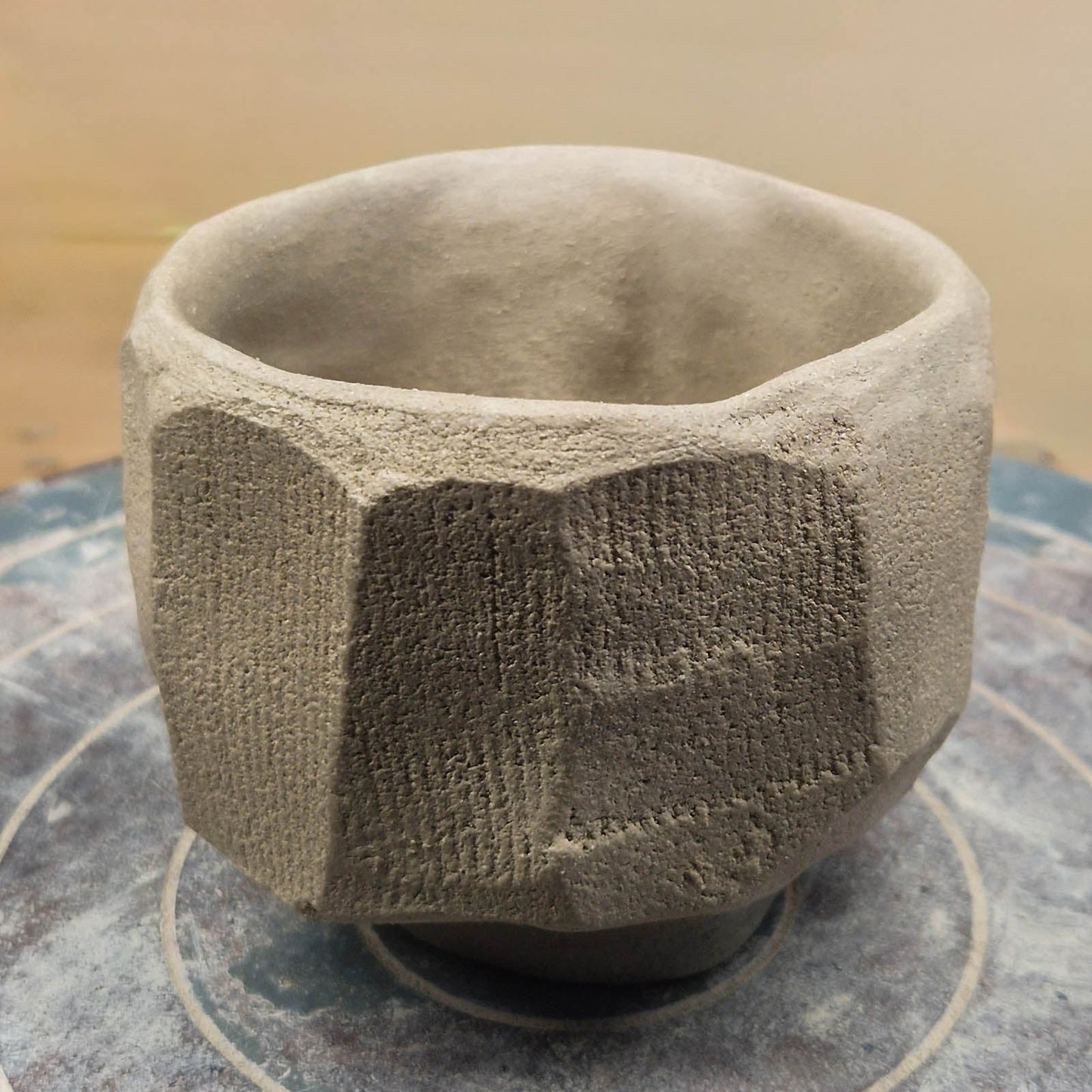 Textured ceramic matcha cup on a stone surface with a neutral background