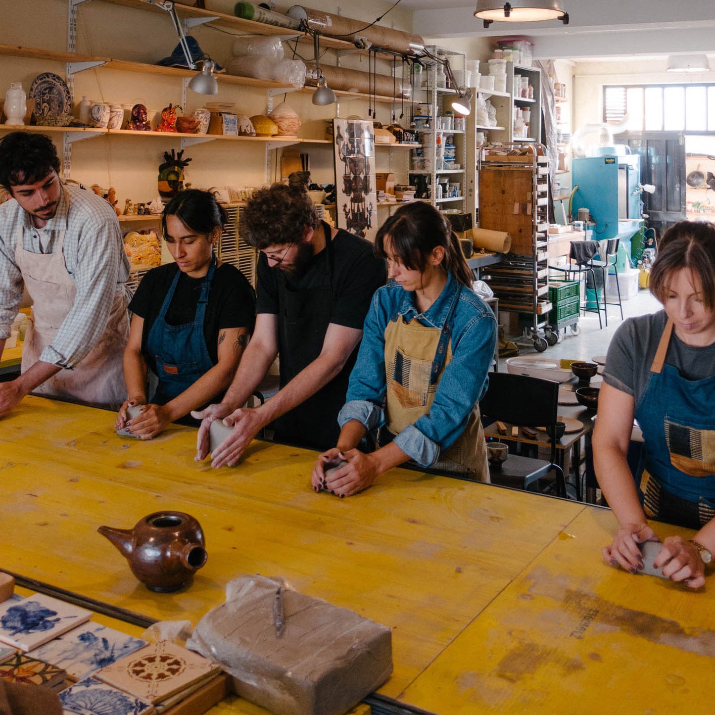 Group of people working with clay in a pottery studio.