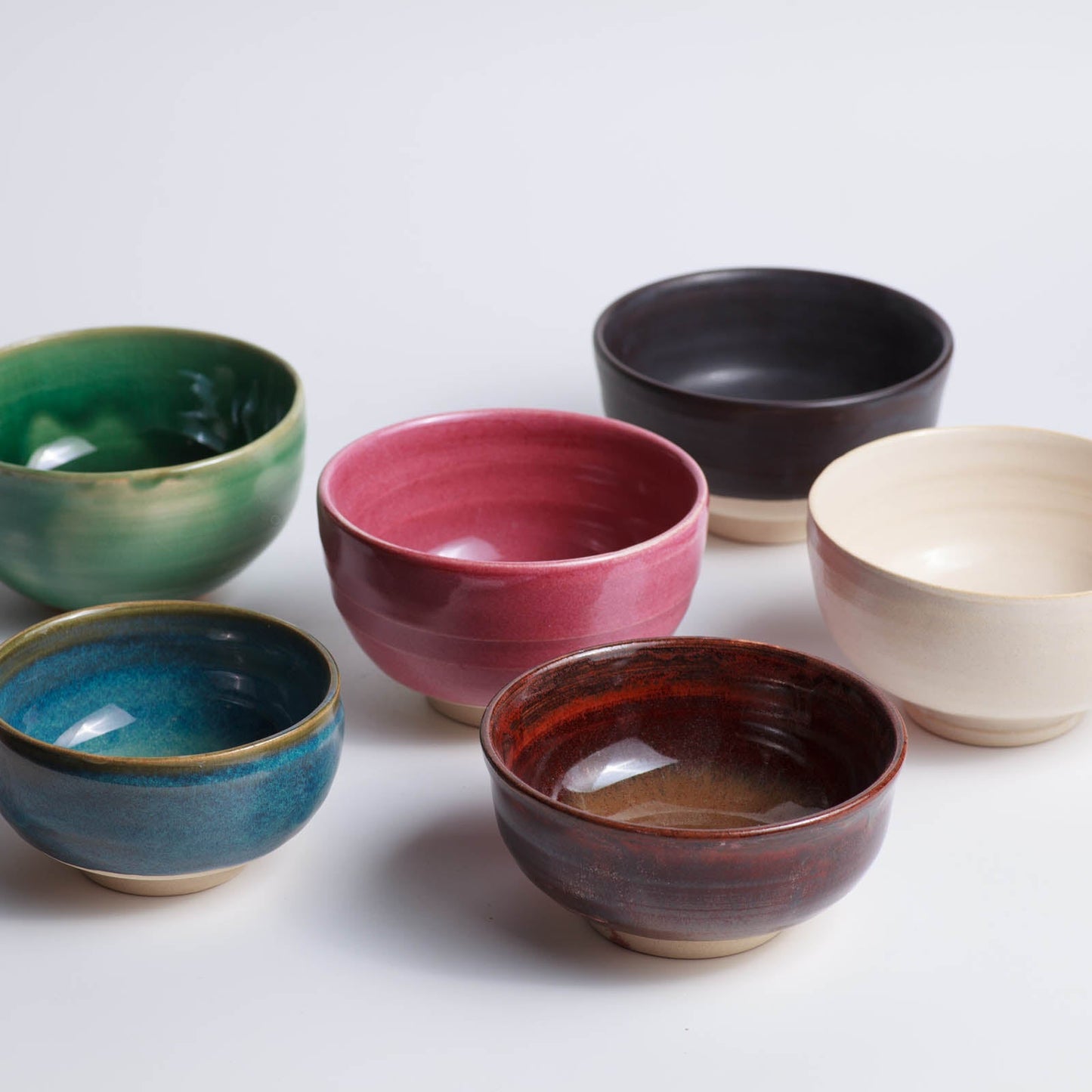 Set of colorful ceramic bowls on a light background