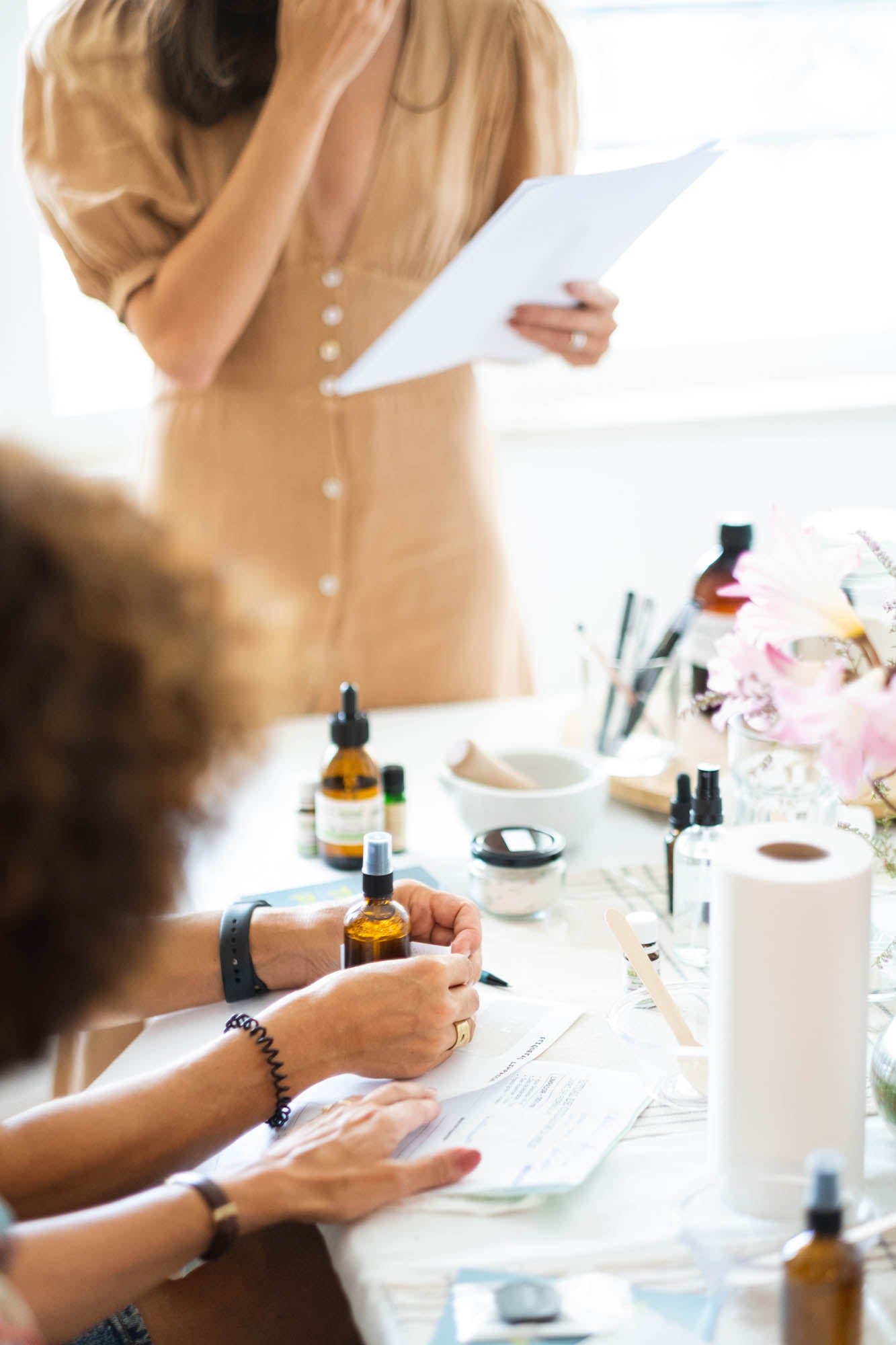 People sitting around a table with bottles and papers, possibly in a meeting or workshop setting.